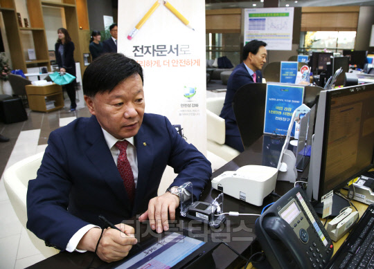 김원규 NH투자증권 사장이 영업점에서 전자문서를 이용해 현금을 출금하고 있다. NH투자증권 제공.